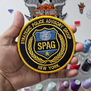 Finished embroidered patch held against the thread wall it was stitched from