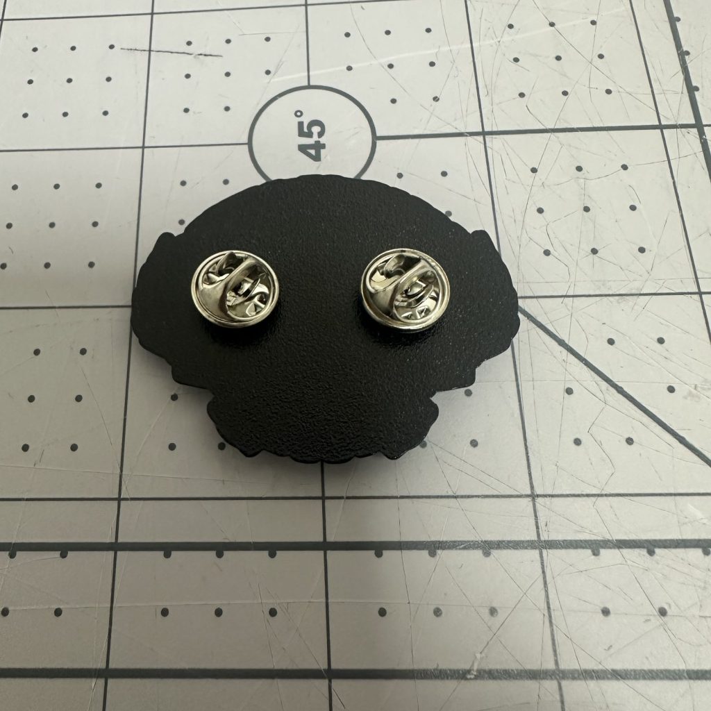 Reverse of a custom enamel pin showing the butterfly clutch fittings