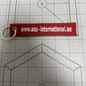 Custom embroidered keychain tag in red with white text