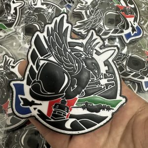 Large custom PVC patch held in hand to show scale